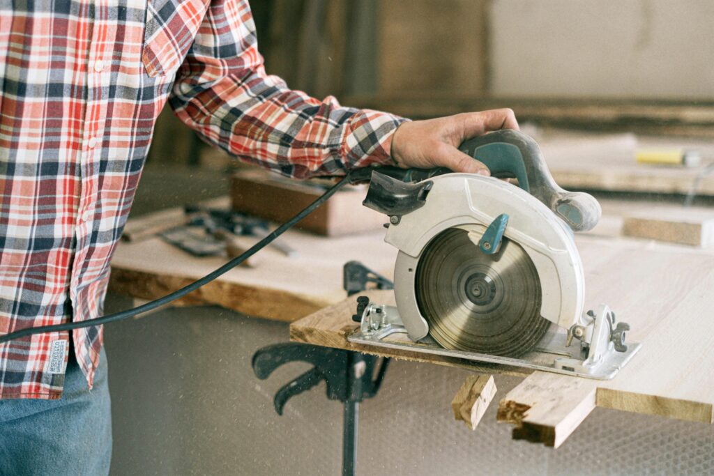 Handyman projects Hamilton. Handyman working with a circular saw on a wooden plank
