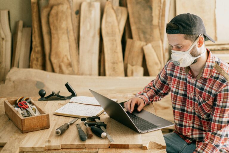 Handyman on a computer with schedule and tools around in Hamilton