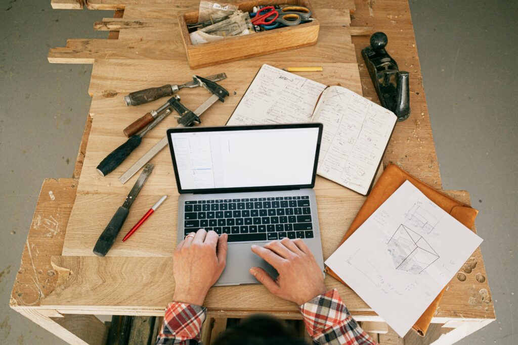 Handyman planning a project on a laptop with tools in Hamilton