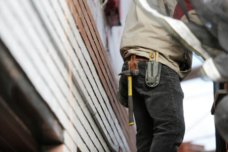 Handyman working on exterior siding in Hamilton