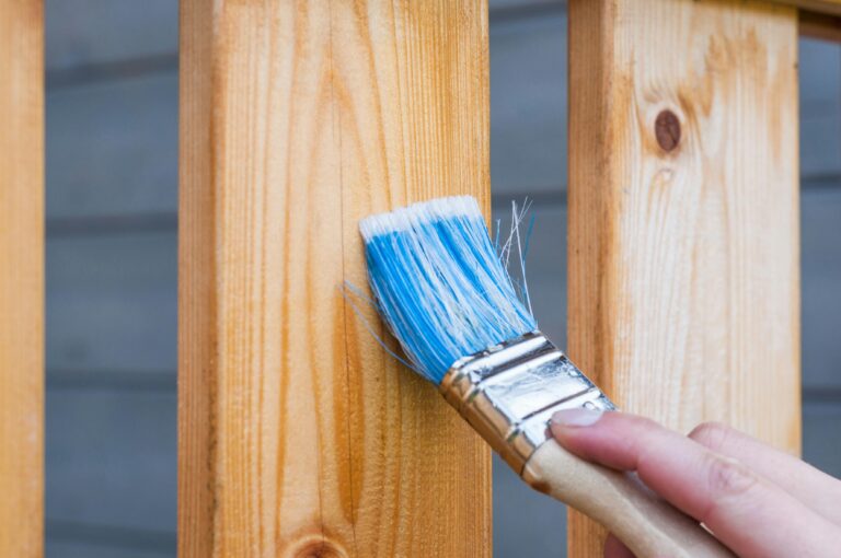 Handyman painting a wooden fence in Hamilton